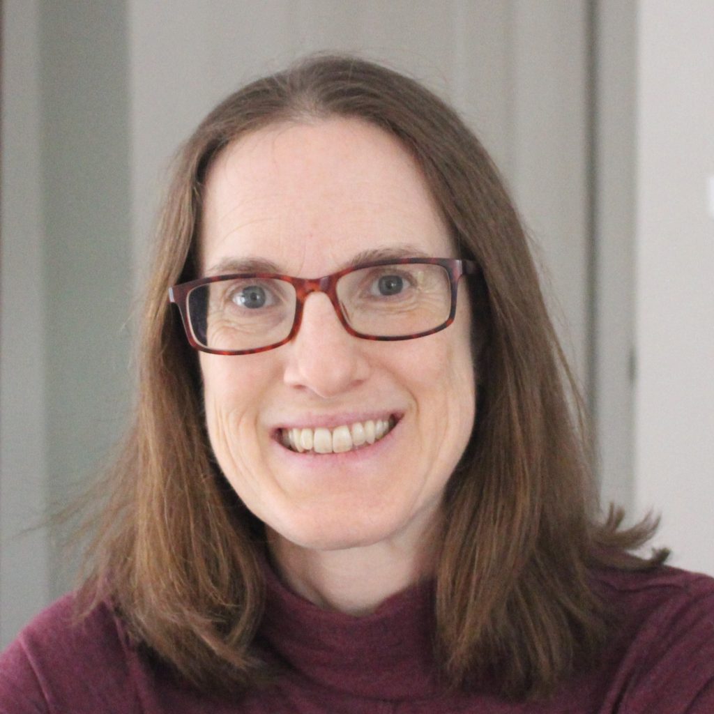 Heather Sinclair author photo - a girl smiling and wearing red glasses